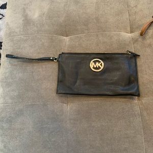 Michael Kors wristlet. Black and gold zipper and symbol on front